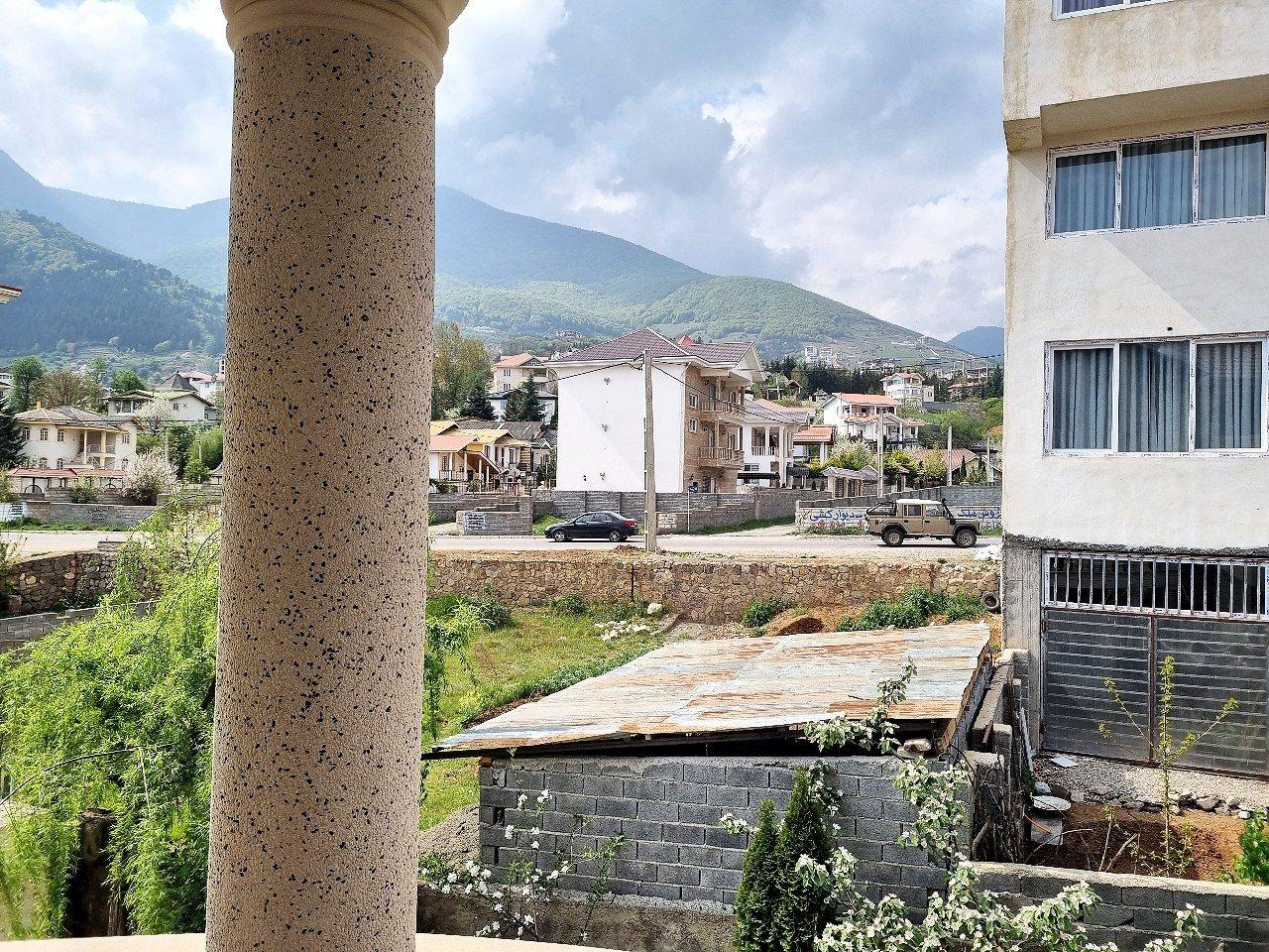 ساختمان رو به جنگل و علم کوه